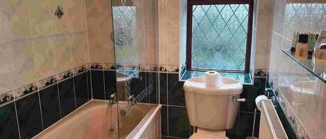 Un baño con bañera, inodoro y lavamanos.