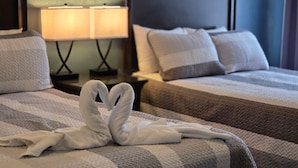 A hotel room with two beds, a nightstand with lamps, and a decorative wall piece. - Family Getaway Heated Pool Orlando Disney (Kissimmee)