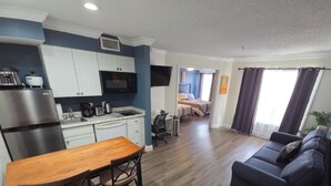 A compact living space with a kitchenette, a dining area, and a seating area. - Family Getaway Heated Pool Orlando Disney (Kissimmee)