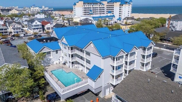 A multi-story hotel with a swimming pool, located near a beach. - OCbeachparadise, Paradise Off The Boardwalk (Ocean City)