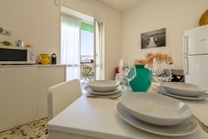 Una cocina moderna con comedor, un balcón y vistas, además de un refrigerador.