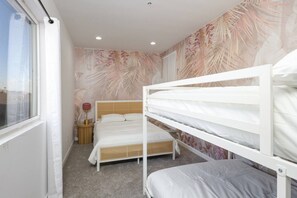 A bedroom with bunk beds, a bedside lamp, and a window. - SD Lux Oasis: Theatre, Spa, 14Beds, AC, Sleeps 20+ (Spring Valley)