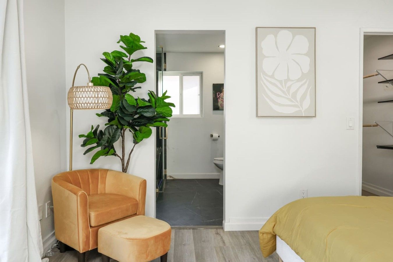 A modern bedroom with a sofa, a floor lamp, and a painting.