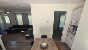 Eine moderne Küche mit einem Holztisch, schwarzen Stühlen und einem eingebauten Backofen.