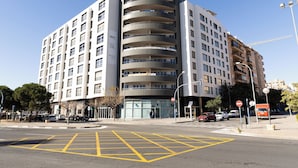 Un edificio de varios pisos con un diseño arquitectónico moderno, que cuenta con balcones y ventanas amplias.