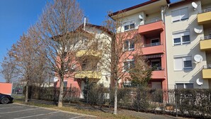 A multi-story residential building with balconies, satellite dishes, and a parking lot. - Apartment Golf in  the Spa of Bük, near thermal baths and golf course (Bük)