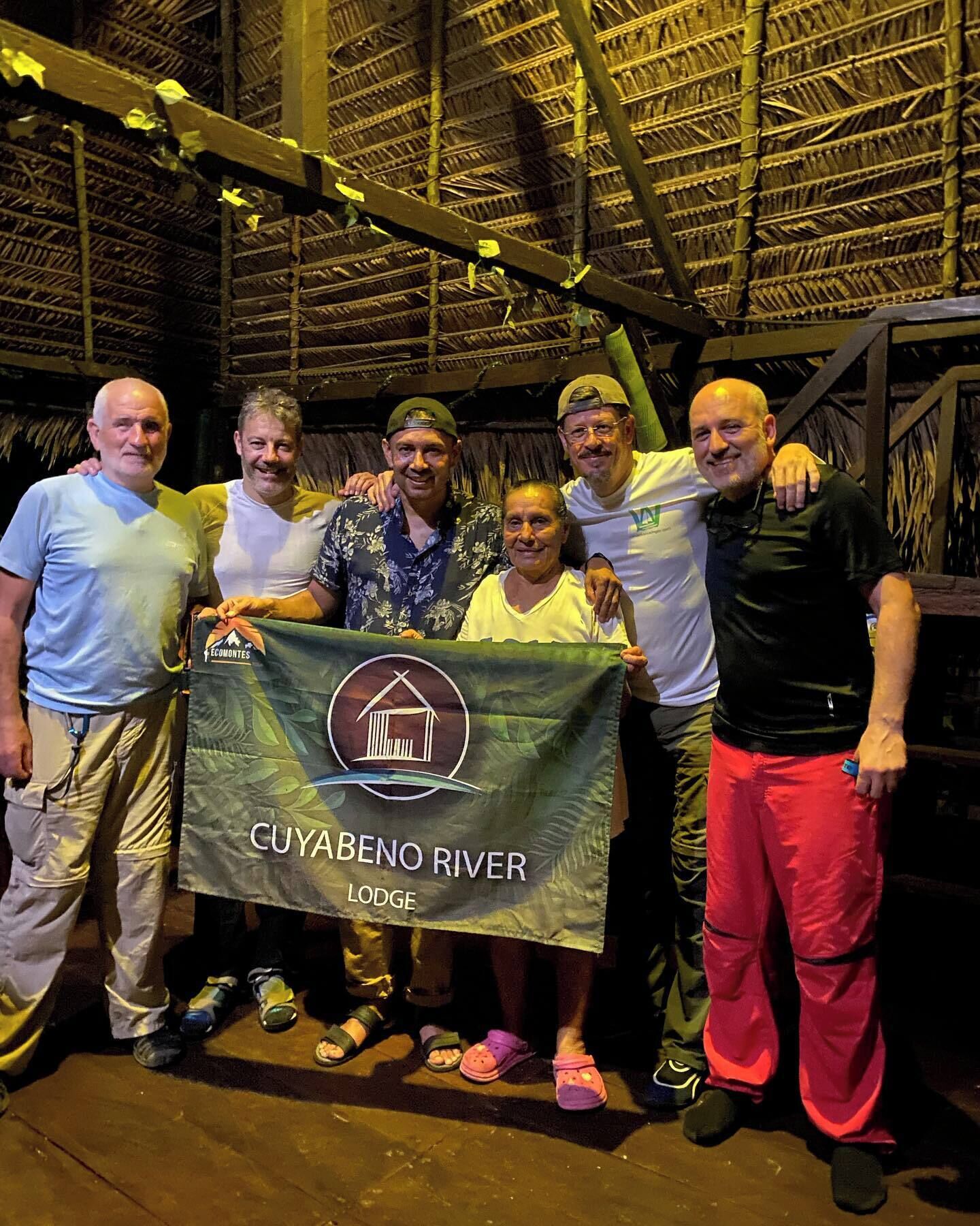 A group of people holding a banner for Cuyabeno River Lodge.