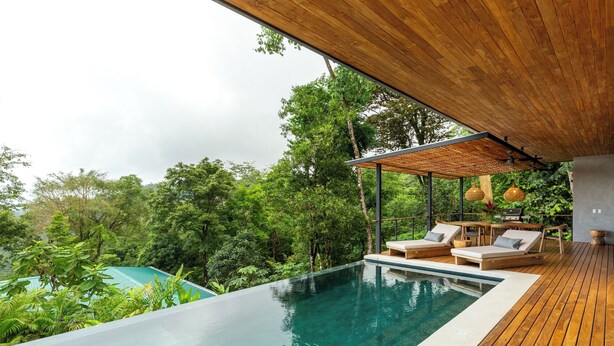 A modern outdoor pool area with wooden decking, lounge chairs, and a pergola. - Casa Roca: Luxury Jungle Retreat with Natural Design & Infinity Pool (Santa Teresa de Cobano)