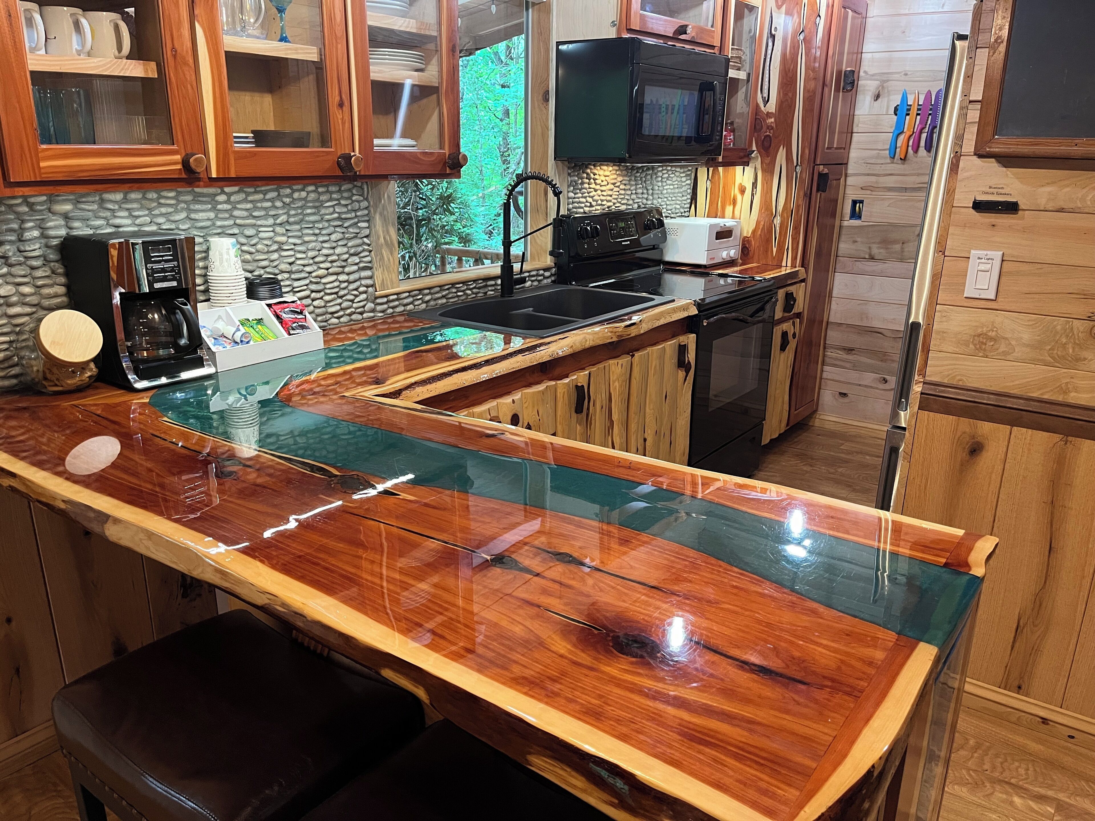 Una cocina con encimera de madera, microondas, cafetera y fregadero.