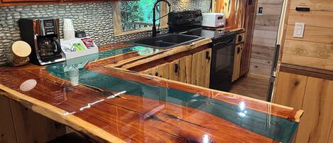 Una cocina con encimera de madera, microondas, cafetera y fregadero.