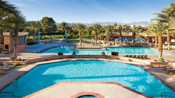 A large outdoor swimming pool with lounge chairs and a hot tub, surrounded by palm trees and a mountainous backdrop. - BNP Paribas Open Tennis Indian Wells 
Marriott Shadow ridge enclaves 2 bed villa (Palm Desert)