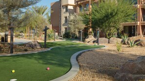 A golf course with a putting green, surrounded by landscaped areas and buildings. - BNP Paribas Open Tennis Indian Wells 
Marriott Shadow ridge enclaves 2 bed villa (Palm Desert)