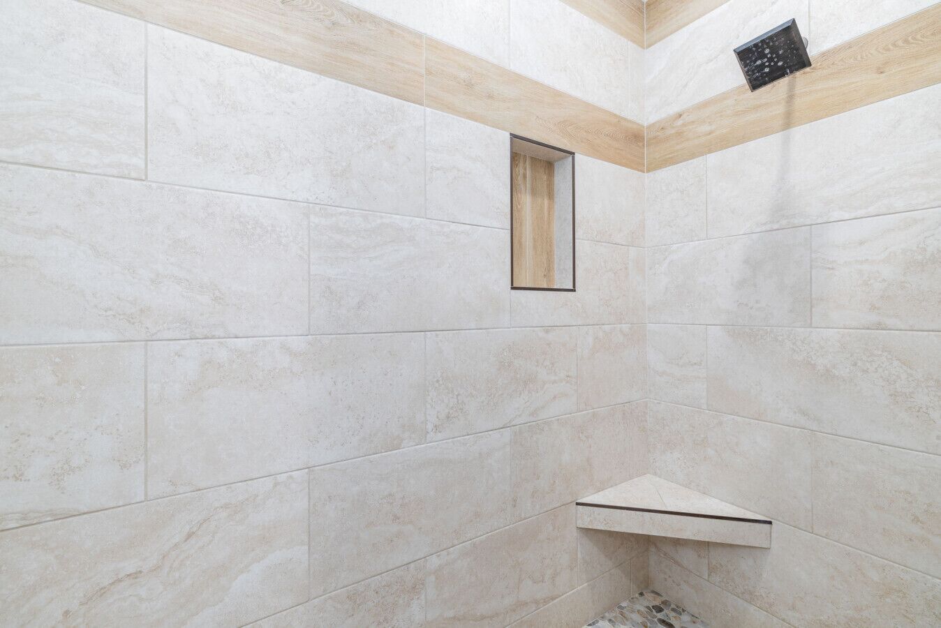A shower with tiled walls and a wooden beam ceiling.