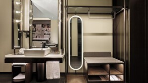 Une salle de bain moderne avec un meuble-lavabo, un miroir et un porte-serviettes.