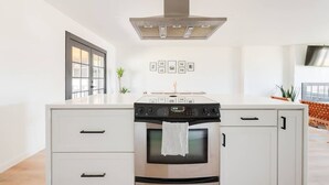 A modern kitchen with a stainless steel oven, a built-in stovetop, and a large window. - Renovated Retreat, Old Town Scottsdale, Sleeps 6 (Scottsdale)