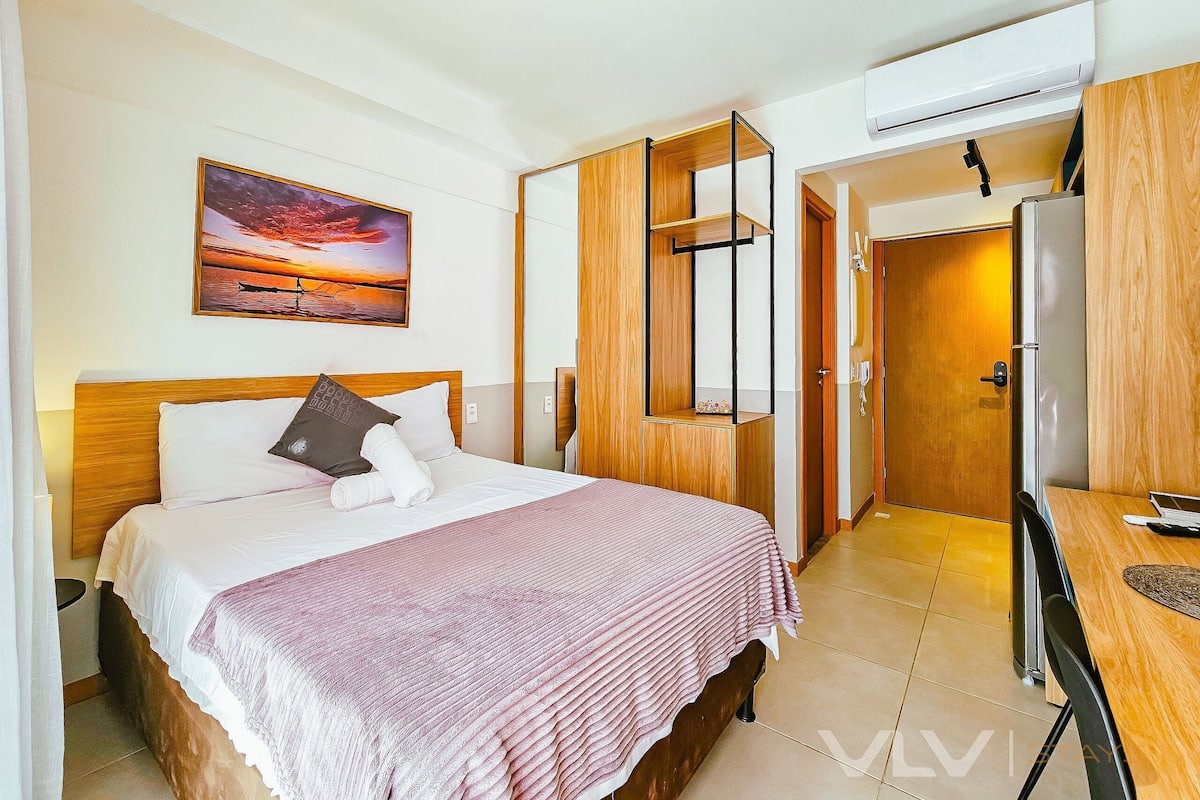 Habitació d'hotel amb un llit, un quadre, un armari i un escriptori.