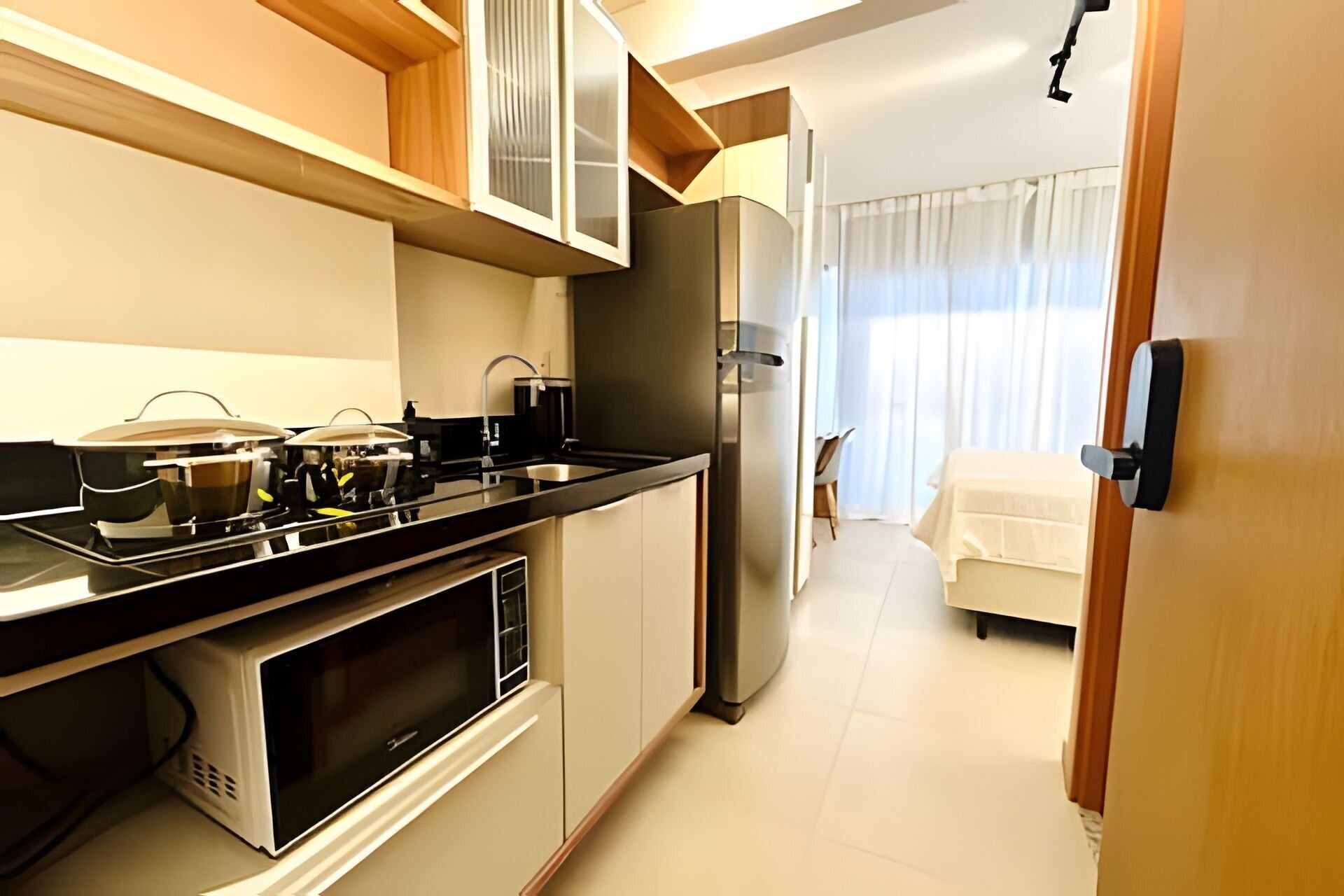 A compact kitchen with a stove, microwave, and refrigerator.
