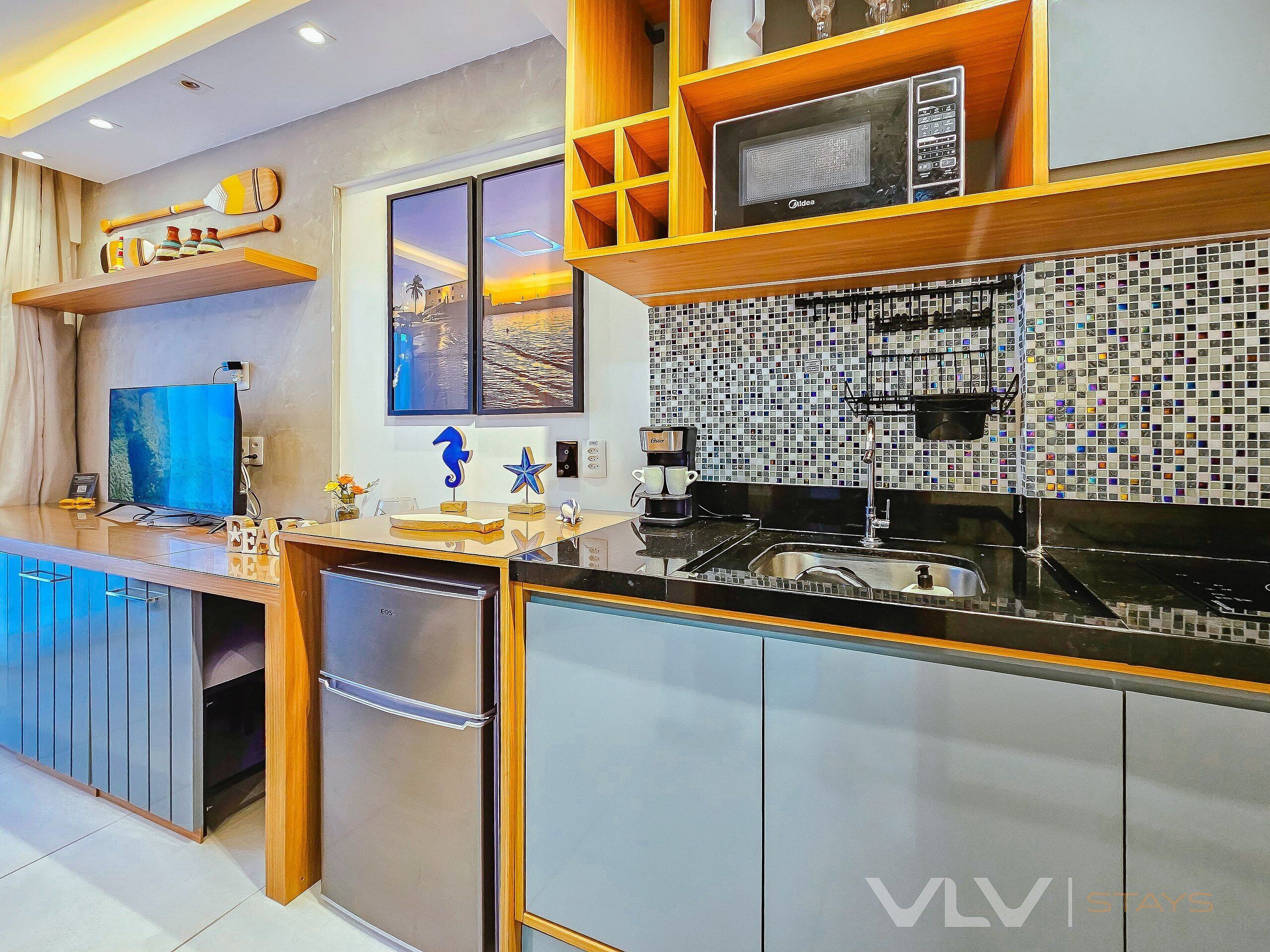 Una cocina moderna con microondas integrado, cafetera y un amplio ventanal con vista a la ciudad.