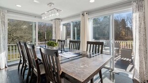 A dining area with a large table, chairs, and a chandelier. - Sakura House: Spacious 4BR w/ Gym & Premium Design (Northborough)