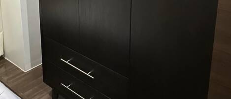 A large, dark-colored wardrobe with two doors and a lower shelf.