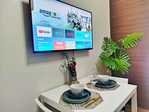 Ein Flachbildfernseher an der Wand zeigt verschiedene Streaming-Dienste.