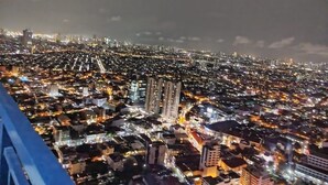 A nighttime cityscape with dense urban lighting and high-rise buildings.