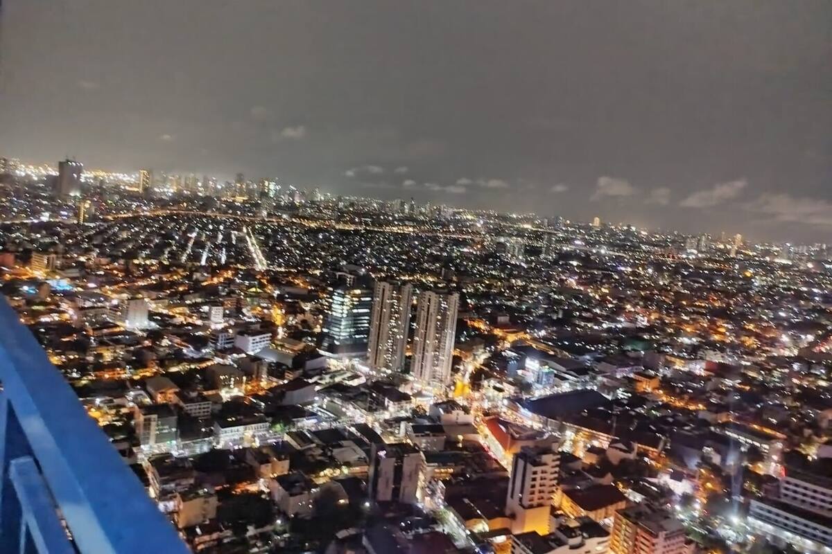 A nighttime cityscape with dense urban lighting and high-rise buildings.