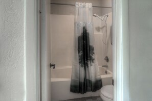 Habitación individual estándar, balcón, vista al jardín | Baño | Tina con regadera, secadora de cabello, toallas, jabón 