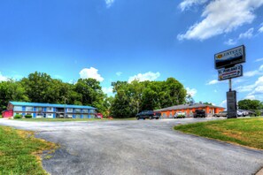 A motel with a blue and orange building, a parking lot, and a sign for Volunteer Inn. - Volunteer Inn at Church Hill near Kingsport (Church Hill)