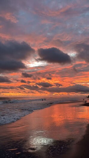 A beach with a sunset, waves, and a few people walking. - Golden Sand: Beach House Escape, Private Pool, Sea Steps Away (Santa Isabel Ishuatan)