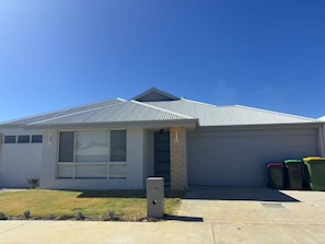 A single-story house with a garage, a large window, and a small front yard. - StayAU 5BRM Idyllic Retreat for Families in Perth (Baldivis)