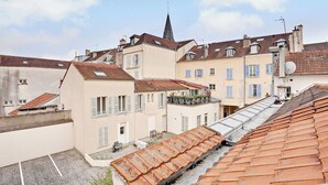 Eine Reihe von Gebäuden mit Terrakotta-Dächern, im Hintergrund ein Kirchturm.