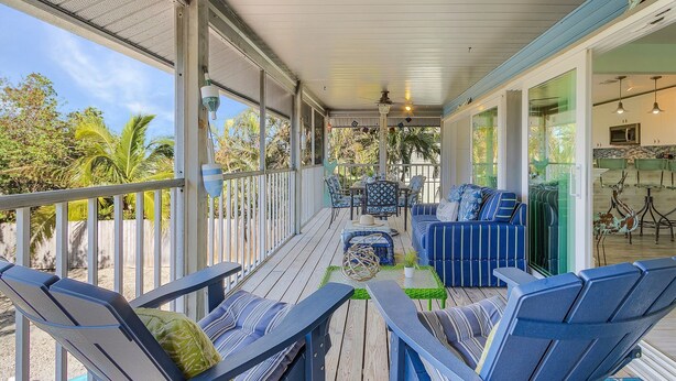A covered outdoor area with seating, a table, and a view of the outdoors. - Close to Beach, Secluded Pier with Partial Bay Views - Blue Bayou B - Roelens (Fort Myers Beach)