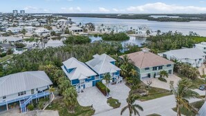 A coastal residential area with houses, a marina, and a clear view of the ocean. - Close to Beach, Secluded Pier with Partial Bay Views - Blue Bayou B - Roelens (Fort Myers Beach)