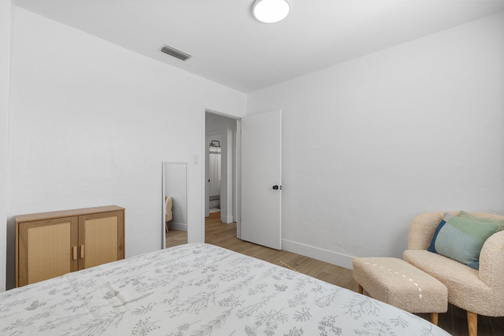 A bedroom with a bed, a wardrobe, a door, and a sofa.