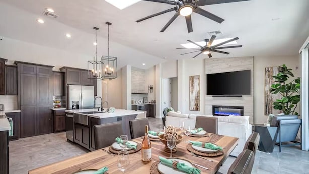 A modern kitchen with dark cabinetry, a central island, and pendant lighting.