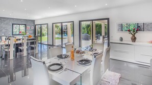 A modern kitchen with a dining area, large windows, and a view of the outdoors. - Vacation home Villa by Interhome (Saint Cyr sur mer Les Lecques)