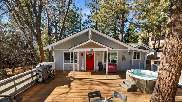 A lodge with a deck, hot tub, and outdoor seating.