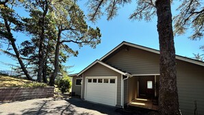 A single-story house with a garage, a front porch, and a driveway. - Fantastic River & Ocean Views! Family Friendly Home, Sleeps 8 (Gold Beach)