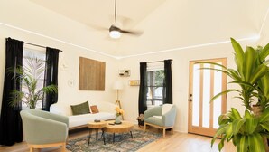 A living room with a sofa, two armchairs, a coffee table, a ceiling fan, and a large plant. - 3-bedroom home in beautiful Atlanta. 10 mins from Mercedes Benz. FIFA World Cup (Atlanta)