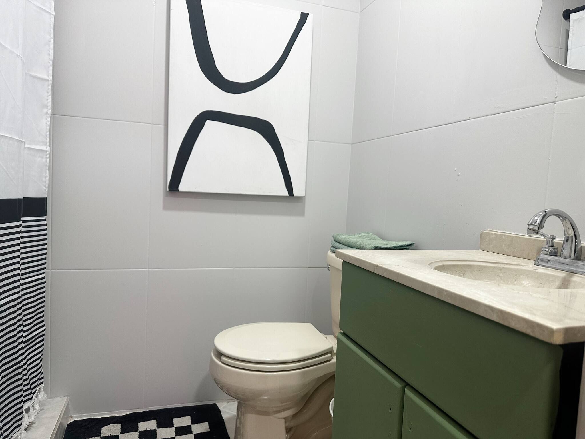 Un bagno con un water, un lavandino e uno specchio.