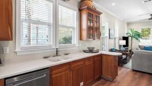 Una cocina con armarios de madera, lavavajillas y pileta.