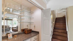 Una cocina con encimeras de granito, una puerta blanca y una escalera de madera.