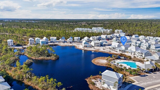 A coastal residential area with houses, a large body of water, and a swimming pool. - Chic Coastal Retreat  Water Views • Pool • Fire Pit • Steps to Beach (Orange Beach)