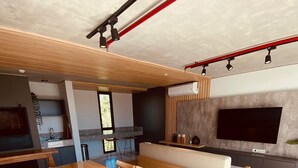 Eine moderne Küche mit Holztisch, integrierten Geräten und einem großen Fernseher.
