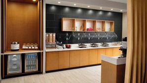 A modern kitchen with a built-in coffee station, a mini-fridge, and a variety of breakfast items. - Springhill Suites By Marriott Troy Dayton (Troy)