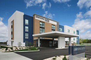 A modern hotel with a flat roof, a covered entrance, and a sign reading "SPRINGHILL SUITES BY HARBORTOWN."