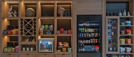 A modern retail space with wooden shelving units displaying snacks, beverages, and household items.