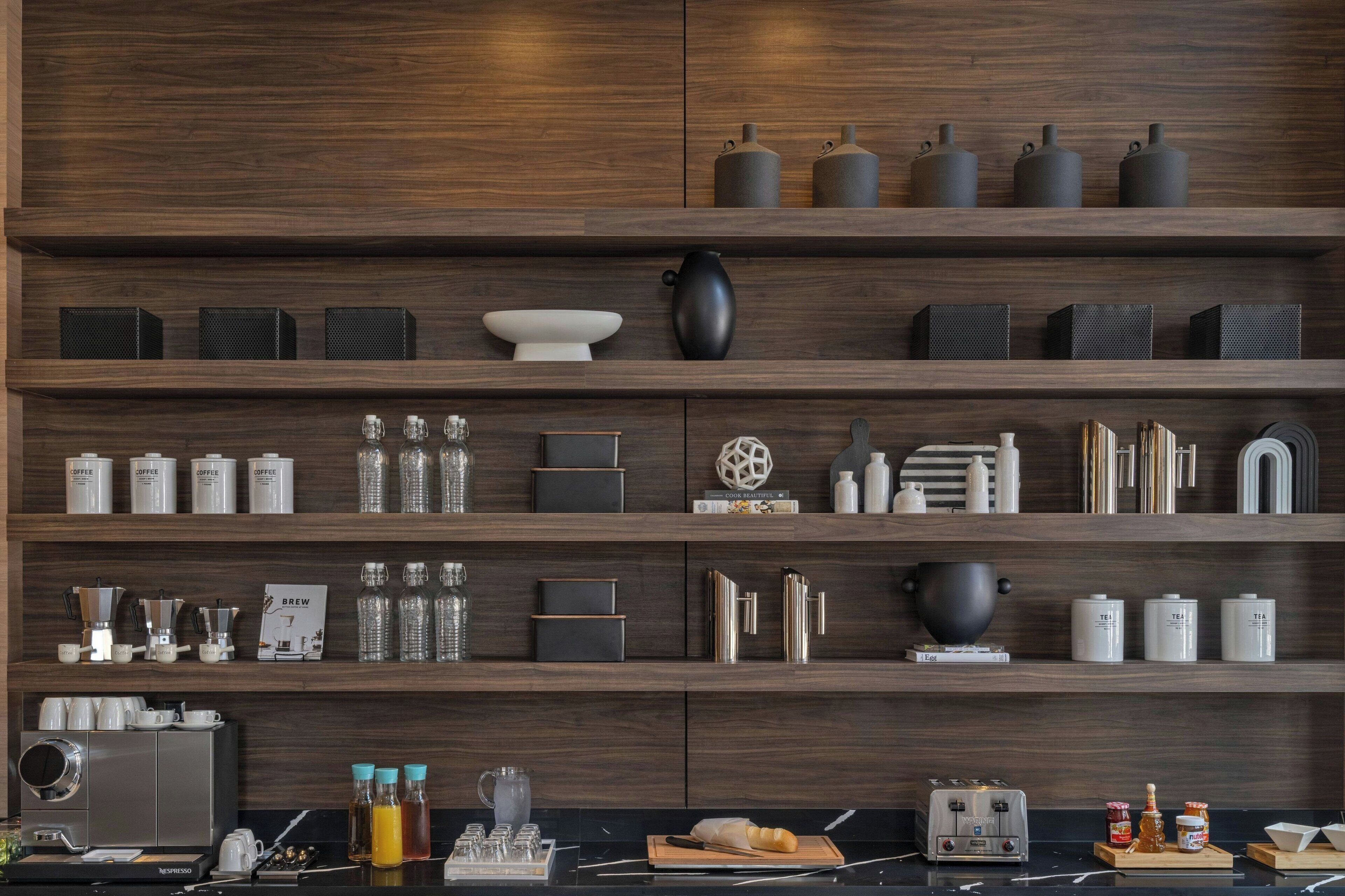 A modern kitchen with wooden shelves displaying various kitchenware and appliances.
