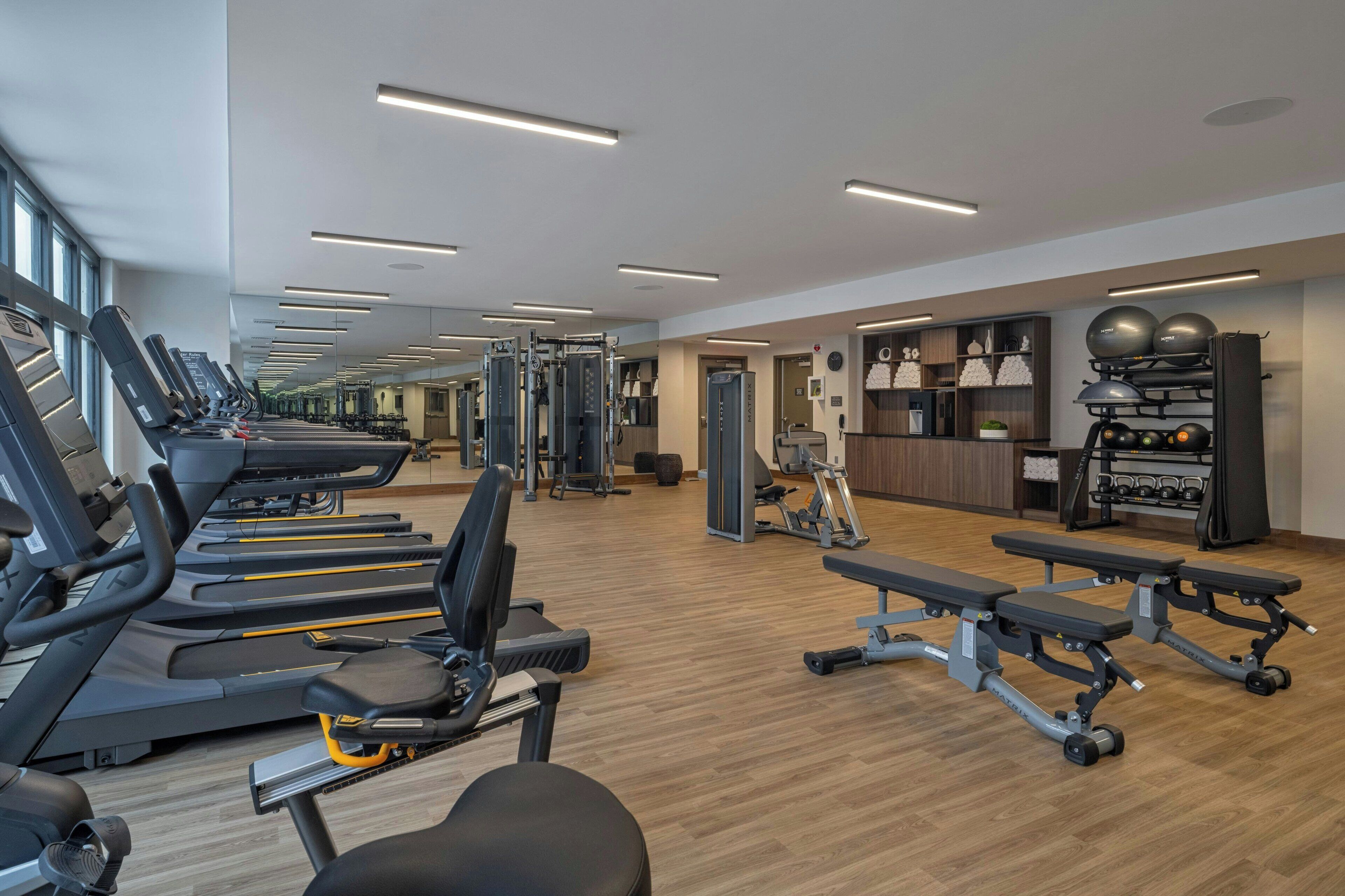 A gym with treadmills, weight machines, and benches.